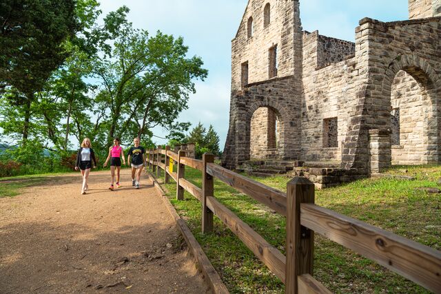 Three women go for a walk past a castle at Ha Ha Tonka State Park.
