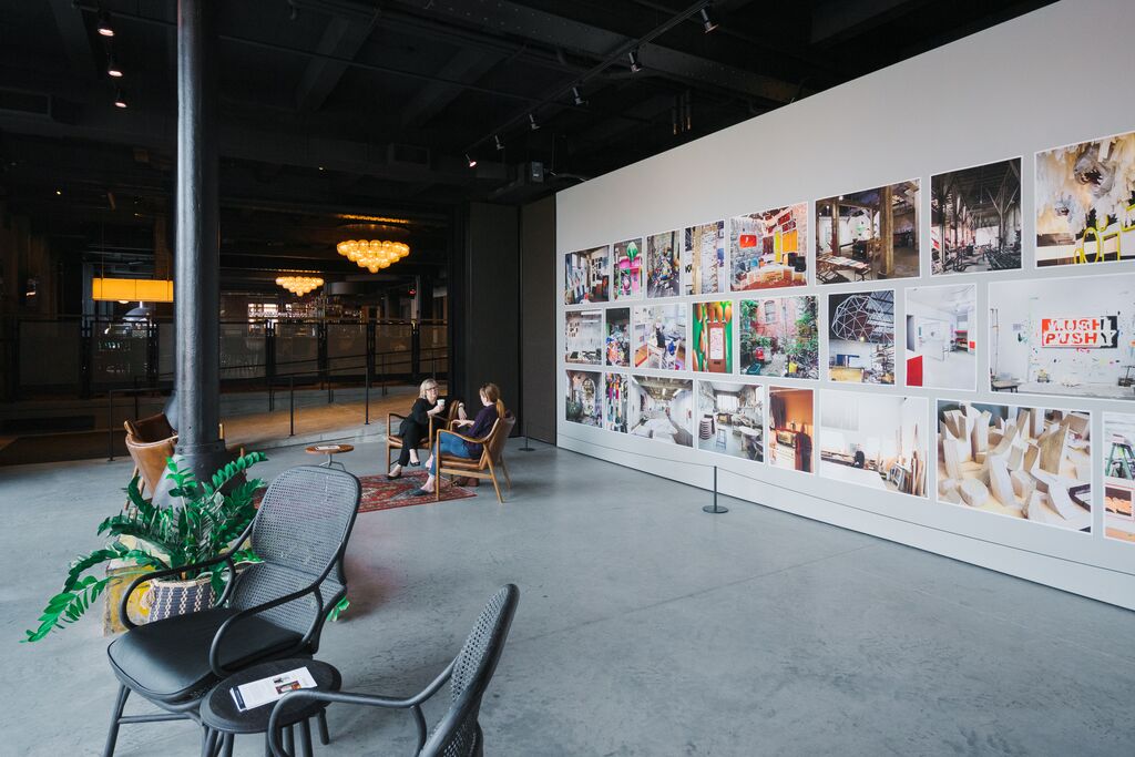 People sit and enjoy a drink in an area of Crossroad Hotel that has art displayed. 